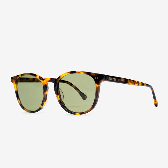Sunglasses with tortoiseshell frame and green lenses on a white background