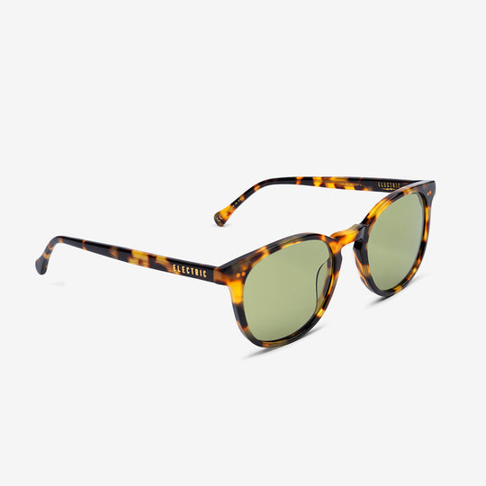 Sunglasses with tortoiseshell frame and green lenses on a white background