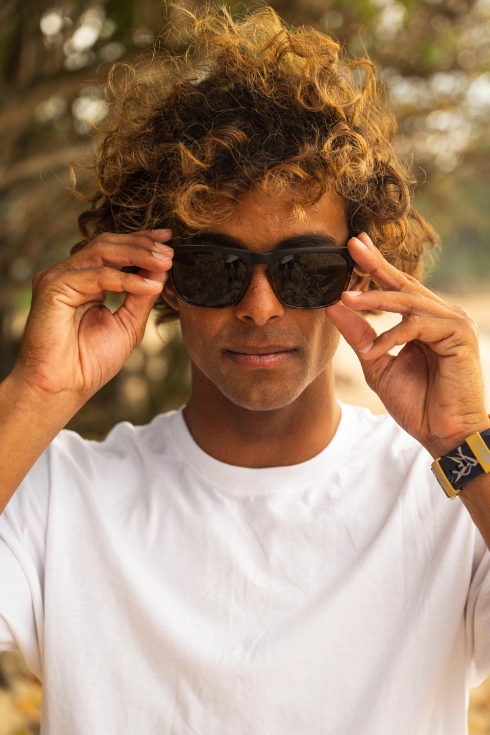 Man wearing sunglasses with a blurred natural background