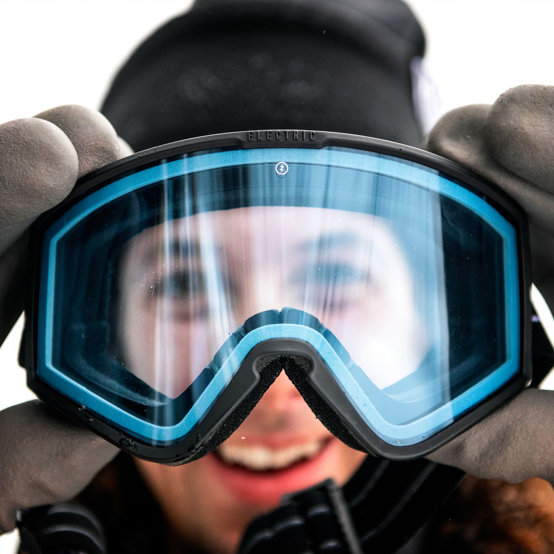 Man holding snow goggle up to his face