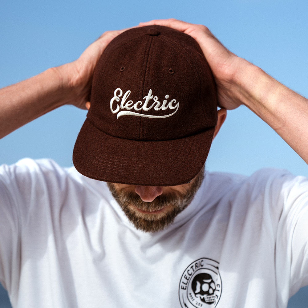electric cursive logo hat in brown. leather enclosure 